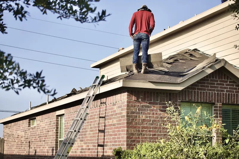 Professional roofer working on a residential roof in Combine